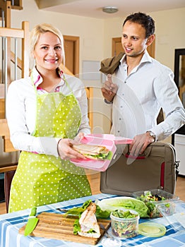 Housewife preparing sandwich for husband