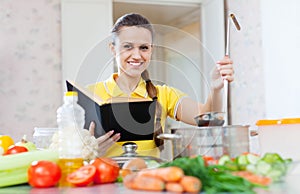 Housewife reads cookbook for recipe