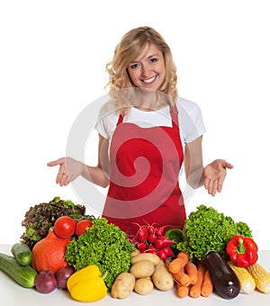 Housewife with red apron presenting fresh vegetables