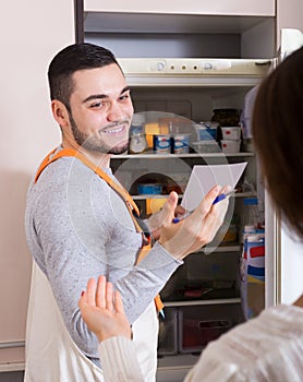 Housewife showing broken refrigerator