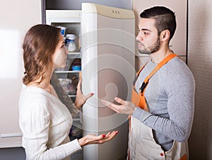 Housewife showing broken refrigerator