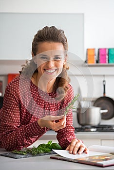 Housewife studying fresh spices herbs in kitchen