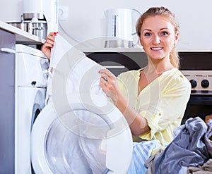 Housewife taking clothes out machine