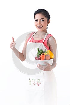 A housewife thump up and hold a bowl of vegetables