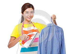 Housewife use iron for straighten of the shirt