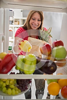 Housewife was in market place and put peppers in fridge