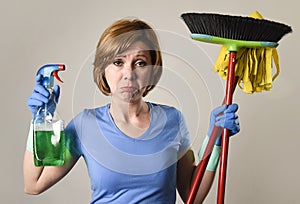 housewife in washing rubber gloves carrying cleaning spray bottle broom and mop