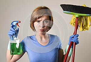 housewife in washing rubber gloves carrying cleaning spray bottle broom and mop