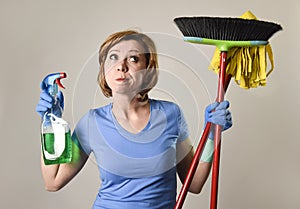 housewife in washing rubber gloves carrying cleaning spray bottle broom and mop