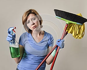 housewife in washing rubber gloves carrying cleaning spray bottle broom and mop