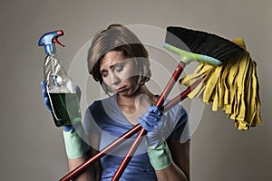 housewife in washing rubber gloves carrying cleaning spray bottle broom and mop