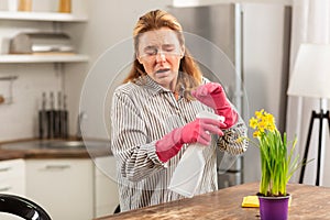 Housewife wearing gloves sneezing having allergy to chemicals