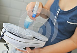 housewife woman applies glass washing liquid to the brushes of a washing robot