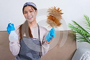 Housework concept, Housemaid is holding feather duster and thumbs up gesture after cleaning house