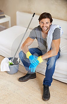 Housework is not just for women. a young man taking a break from cleaning the house.