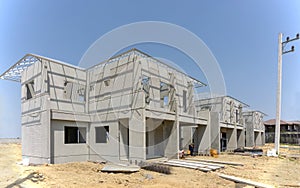 Housing property construction progress, people are building a precast house, the workman working in front the house in a hot day