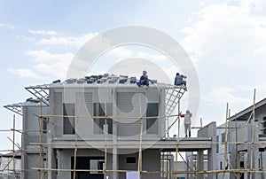 Housing property construction progress, people are building a precast house, the workman working on the roof in a hot day under