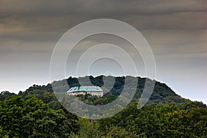 Houska castle in Czech Republic, Central Bohemia, Europe. State caste, hiden in green forest, dark grey clouds. Tower house in lan