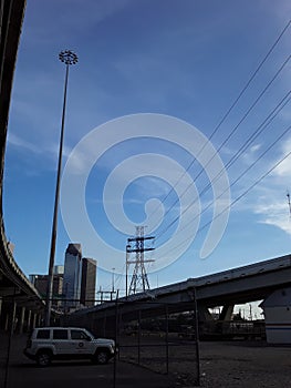 Houston Texas skyline with powerlines, skyscrapers, freeways, wispy clouds and a white car