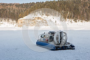 Hovercraft transporter on the ice of river in winter day