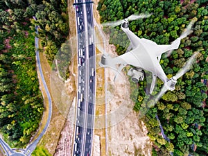 Hovering drone taking pictures of highway in forest, Netherlands