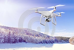 Hovering drone taking pictures of white winter nature