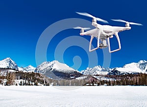 Vznášející se dron fotící bílou zimní přírodu