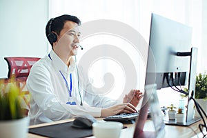 How can I help you? Handsome call center workers in headphones are working at modern office