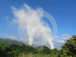 How clouds are made with polluting smoke from industry chimneys photo