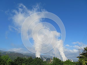 How clouds are made with polluting smoke from industry chimneys photo