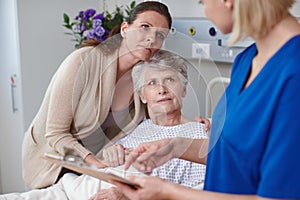 How could this happen. A daughter and her mother looking at the medical report being shown to them by a young nurse.