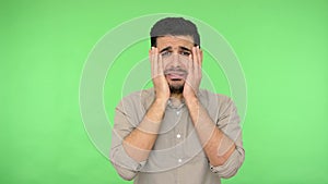 How could you? Frustrated upset brunette man raising hands with indignant annoyed expression. indoor green background