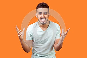 How could you? Portrait of annoyed frustrated brunette man standing with raised hands, asking why. indoor studio shot  on