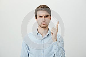 How dare you disobey. Portrait of handsome serious european teacher in blue-collar shirt shaking index finger as if