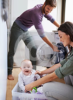 How did you get in here. Shot of a young family having fun while doing laundry.