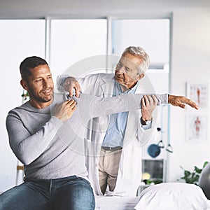 How does this feel. a senior doctor giving his male patient a thorough checkup during his consultation.