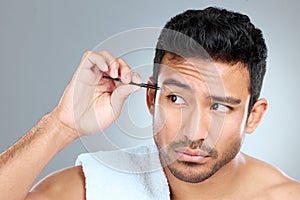 How else am I supposed to have clean brows. a handsome man tweezing his eyebrows.