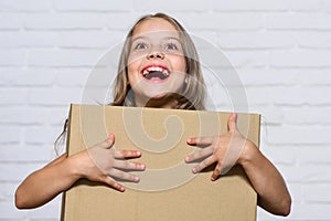 How home should feel. happy childhood. small girl child. little girl with box. moving to new apartment. perfect purchase