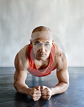 How long can you hold a plank. a fit young man doing plank exercises at the gym.