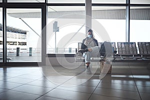 How long is this layover. Shot a young woman sitting with a bags in the airport.