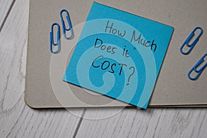 How Much Does it Cost? write on sticky note  on wooden table