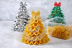 How to make a Christmas tree from raw pasta conchiglie. The process of making Christmas trees from pasta, cardboard plates, hot