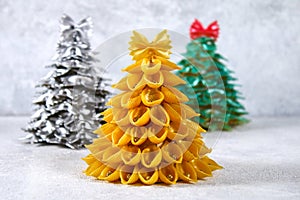 How to make a Christmas tree from raw pasta conchiglie. The process of making Christmas trees from pasta, cardboard plates, hot