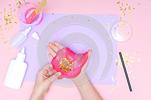 How to make slime at home. Children art project. DIY concept. Kids hands making slime toy on pink. Step by step photo