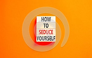 How to seduce yourself symbol. Concept word How to seduce yourself on wooden blocks. Beautiful orange table orange background.