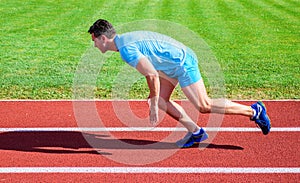 How to start running. Boost speed concept. Man athlete runner push off starting position stadium path sunny day. Runner