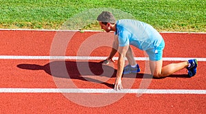 How to start running. Sport motivation concept. Man athlete runner stand low start position stadium path sunny day