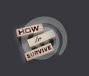 How to Survive words on wooden blocks. Surviving in wild nature concept. Desease and epidemy survival healthcare