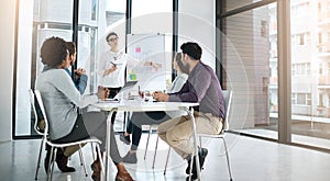 This is how we will head to the top. a businesswoman giving a presentation to her colleagues in a modern office.