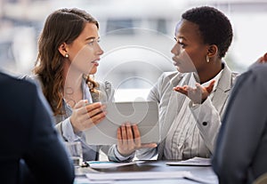 How would clients resonate with this. two young businesswomen sitting together in the office and having a discussion